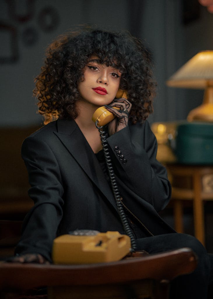 Woman with Curly Hair Talking on Corded Phone